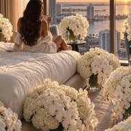 A bedroom banked with white orchids and hydrangea